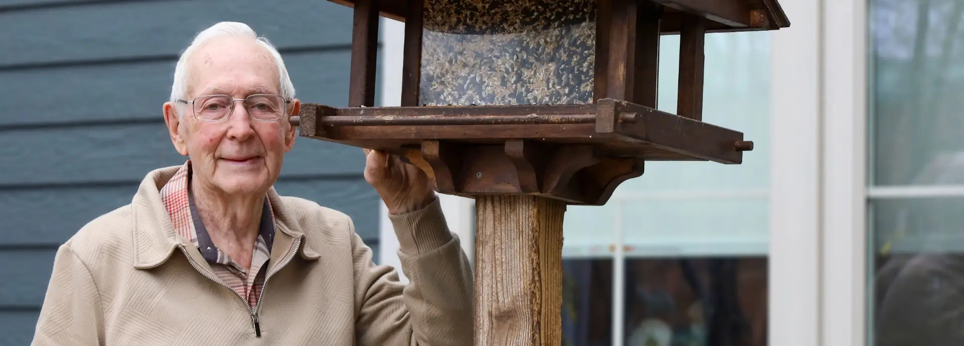 Photo of George Christie holding a bird cage